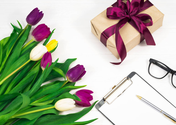 bloemen op een witte achtergrond en een geschenk - Foto, afbeelding