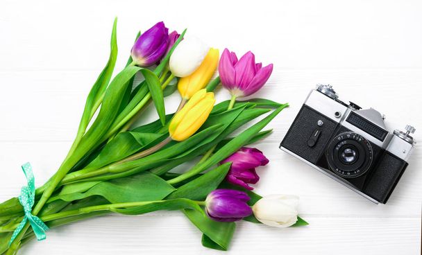 λουλούδια και κάμερα σε λευκό φόντο - Φωτογραφία, εικόνα