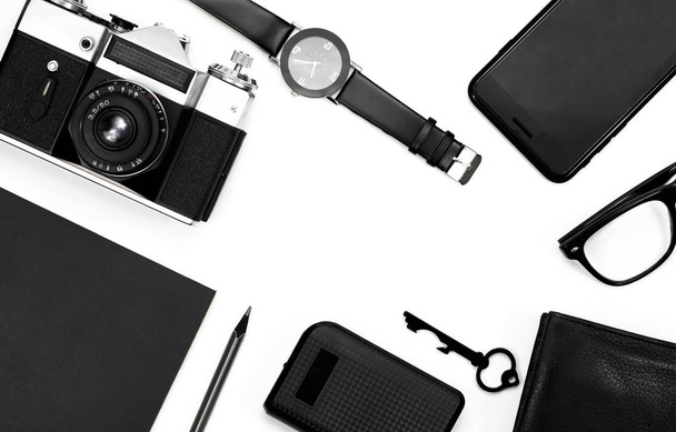 fekete clock, fekete ceruza, fekete Jegyzettömb, fényképezőgép, fekete szemüveg, kulcs, pénztárca, fehér háttér - Fotó, kép