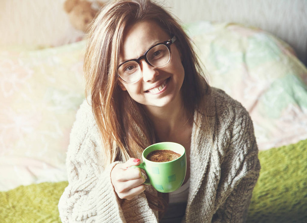 Portret van vrolijk meisje, drinken koffie in bed - Foto, afbeelding