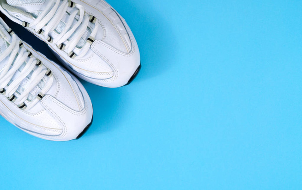 λευκά sneakers σε μπλε φόντο - Φωτογραφία, εικόνα