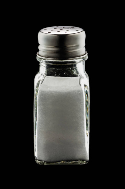Un vaso agitador de sal de mesa aislado sobre fondo negro con camino de recorte
 - Foto, imagen