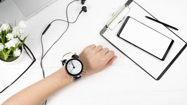 weibliche Zeiger und Armbanduhr, Laptop, Telefon, Holzhintergrund - Foto, Bild
