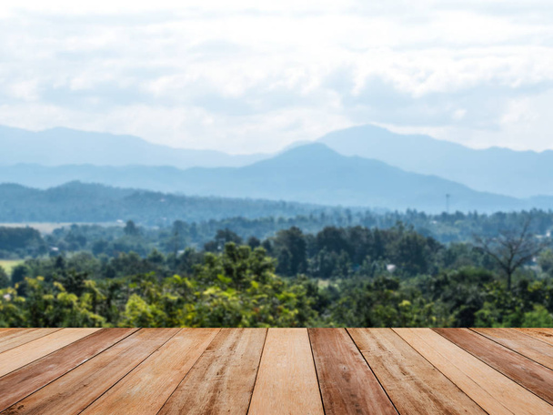 青い空を背景に山と熱帯の森林景観上トップの木のテーブル。製品を表示するモンタージュ スタイル. - 写真・画像