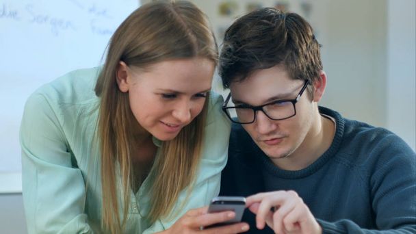 Teens reading some content in smartphone that makes them smile - Photo, Image