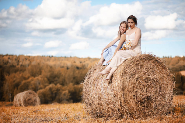 Deux filles en robes dans le champ d'automne
 - Photo, image