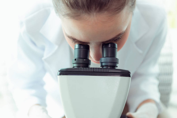 Πορτραίτο, νέος επιστήμονας έρευνας χρησιμοποιώντας μικροσκόπιο σε ένα εργαστήριο., βιοτεχνολογία, επιστήμη, χημεία. - Φωτογραφία, εικόνα