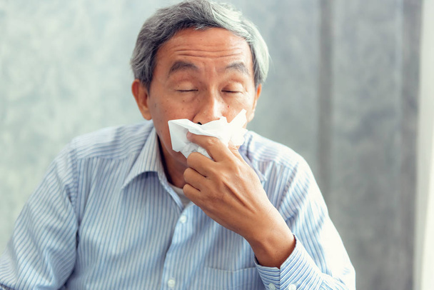 Hombre mayor que tiene enfermedad y estornudos en el tejido., Concepto de salud
. - Foto, Imagen