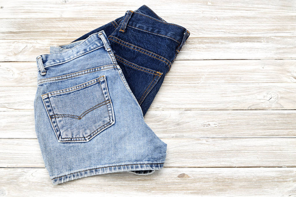 zwei Vintage-Jeans-Shorts auf einem Holzregal. Shorts aus neuer Kollektion - Foto, Bild