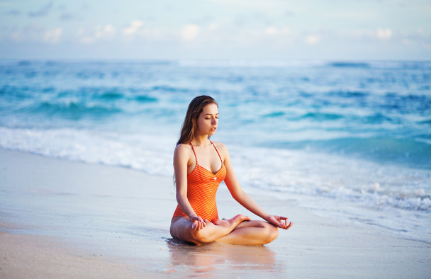 Young woman doing yoga on the beach - Zdjęcie, obraz