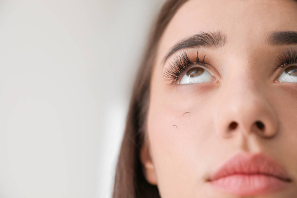Young woman with eyelash loss problem on light background, closeup - Fotoğraf, Görsel