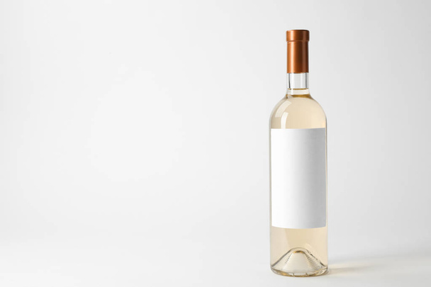 Bottle of delicious wine with blank label on white background - Fotó, kép