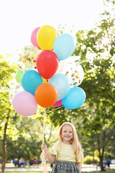 Cute little girl with colorful balloons outdoors on sunny day - Fotoğraf, Görsel