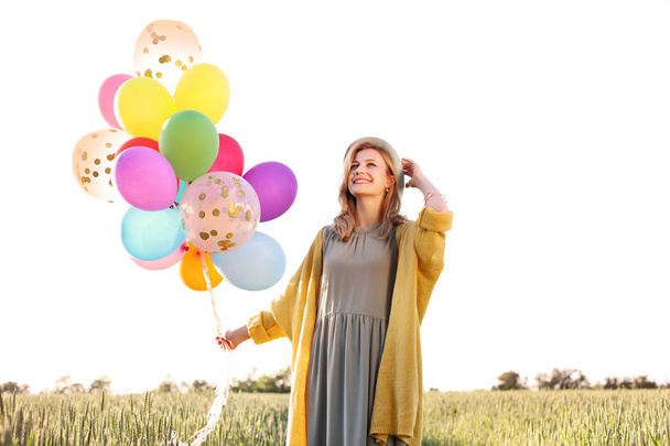 Młoda kobieta z kolorowych balonów na zewnątrz w słoneczny dzień - Zdjęcie, obraz