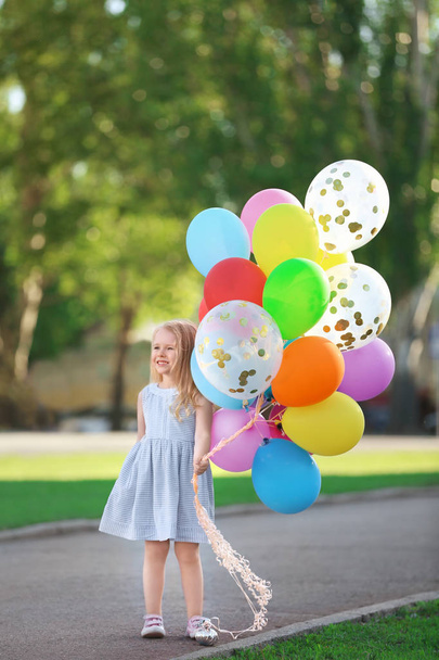 Cute girl with colorful balloons in park on sunny day - Fotoğraf, Görsel