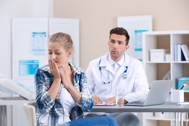 Coughing young woman visiting doctor at clinic - Photo, image