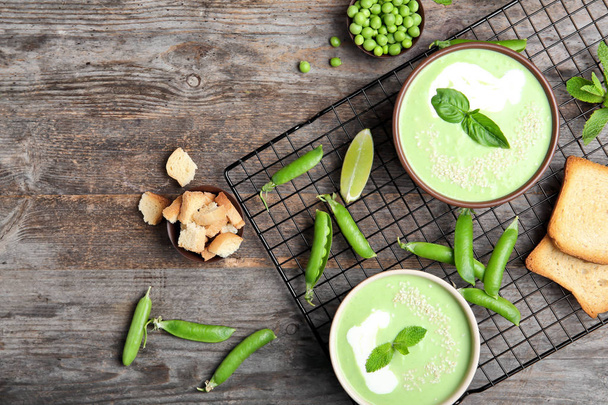 Flat lay composition with green pea soup on wooden background - Foto, Imagem