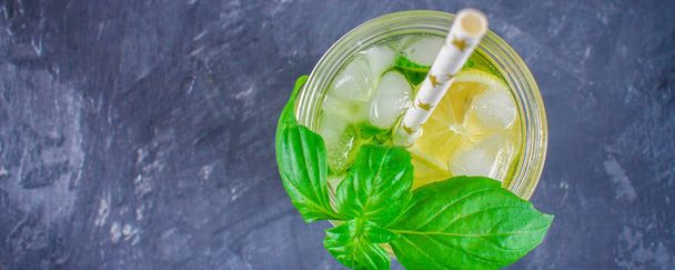 Top view. Sassy diet water. Cucumber, lemon, mint lemonade in glasses on grey background - Foto, Imagem