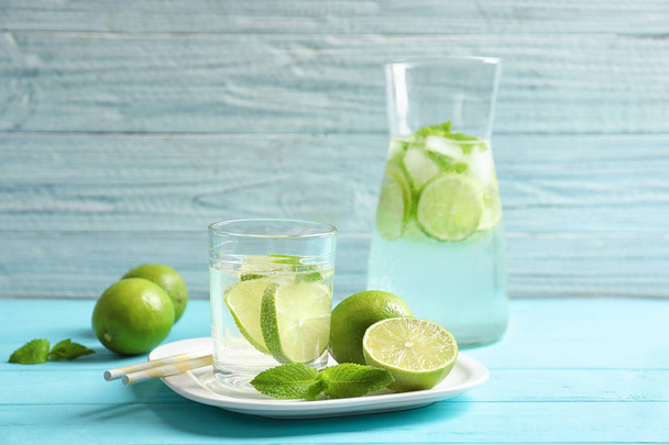 Natural lemonade with lime in glassware on wooden table - Foto, afbeelding