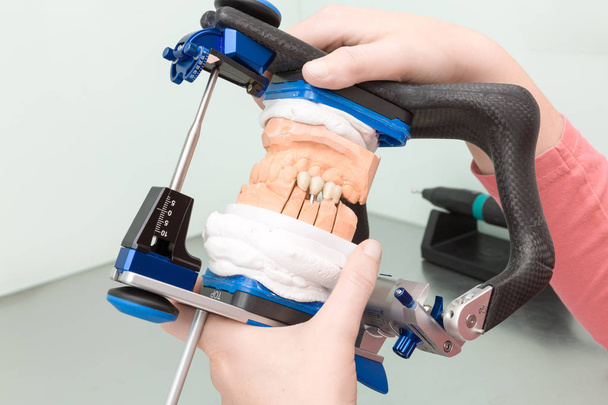 working on artificial dentition in a dental laboratory - Foto, Bild