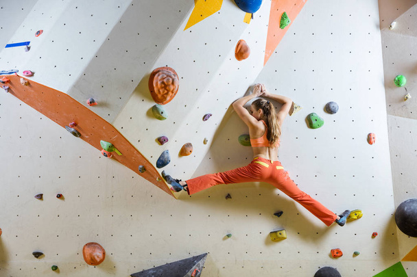 Young woman climbing challenging bouldering route - Photo, Image