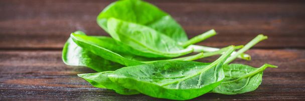 Green fresh spinach leaves on a wooden table - 写真・画像