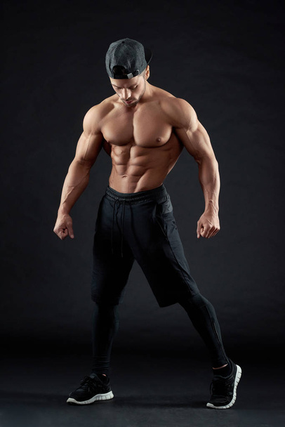 Photo of posing bodybuilder wearing a cap. - Foto, afbeelding