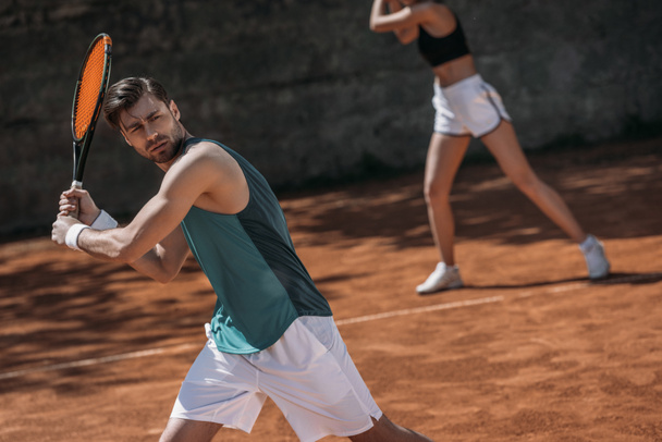 mladý sportovní pár hrát tenis jako tým - Fotografie, Obrázek