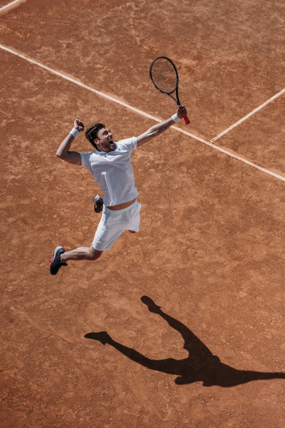 visão de alto ângulo do jogador de tênis atlético fazendo hit no salto
 - Foto, Imagem