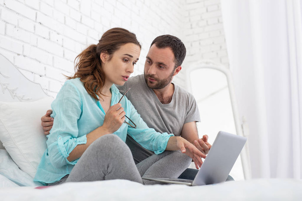 Concerned pregnant woman and man watching video - Foto, immagini