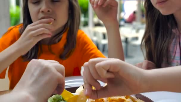 Twee kleine meisjes, eten in een fast-food café buitenshuis. - Video