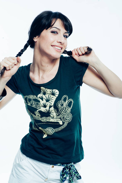 Young caucasian brunette with tail hair having fun in studio. White background, green shirt dressed. Copy space - Photo, Image