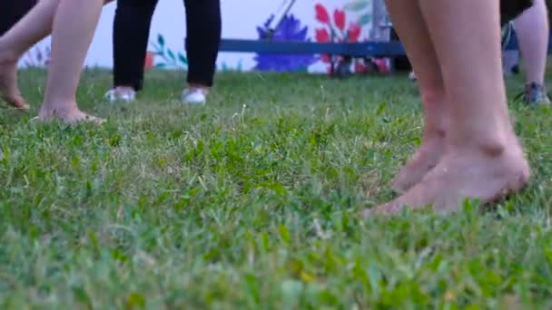 Grondniveau weergave van vrienden springen en dansen blote voeten in de tuin op een zomer feest - Video