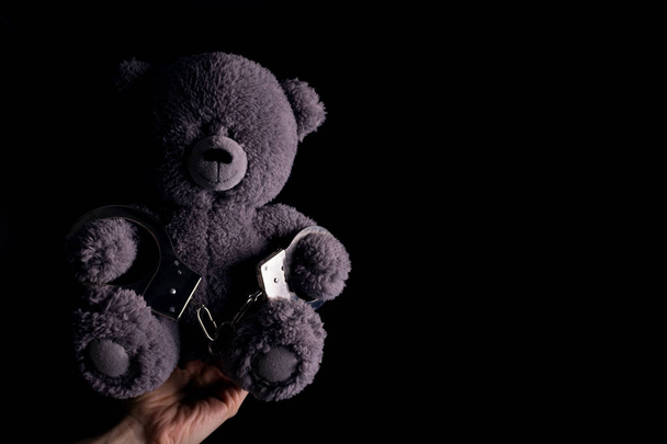 teddy bear in handcuff. child crime concept - Zdjęcie, obraz