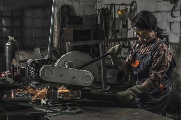 female welder in protective googles using welding torch in workshop - Photo, Image