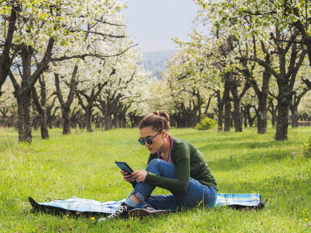 Mujer joven usando su tableta al aire libre
 - Foto, imagen