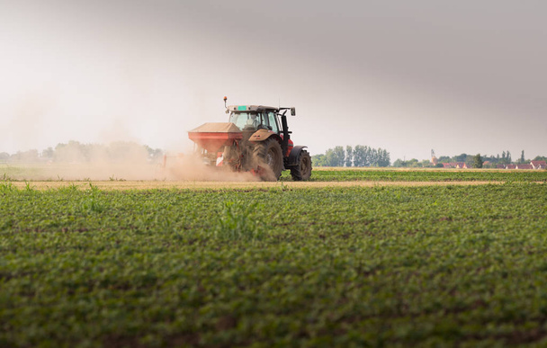 Traktör tohumu olan çiftçi - ilkbaharda tarım tarlalarına ekin ekiyor. - Fotoğraf, Görsel