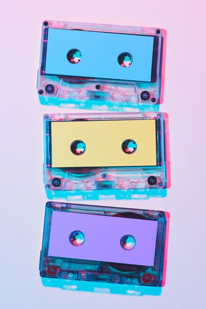 top view of arranged colorful audio cassettes on purple background - Фото, изображение