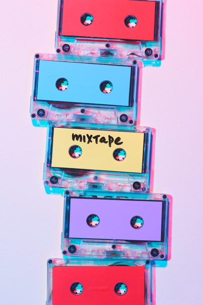 top view of arranged colorful audio cassettes with mixtape lettering on purple background - Фото, зображення