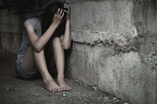 Sad κορίτσι που κάθεται στην γωνία, λόγω της σεξουαλικής κακοποίησης, εμπορίας και σταματώντας βία κατά των γυναικών, παγκόσμια ημέρα της γυναίκας - Φωτογραφία, εικόνα