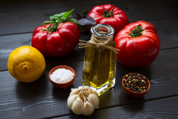 Ripe tomatoes, olive oil, basil, garlic, lemon and spices. Ingredients of Italian cuisine for vegetable salad. FoodPhoto. Vegetarian foods. - Foto, Bild