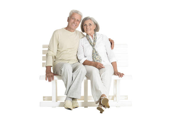 portrait of  senior couple sitting on bench  isolated on white background, full length - Фото, изображение