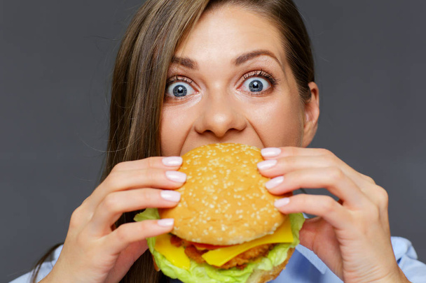 portrait of hungry woman eating burger, close-up  - Foto, Bild