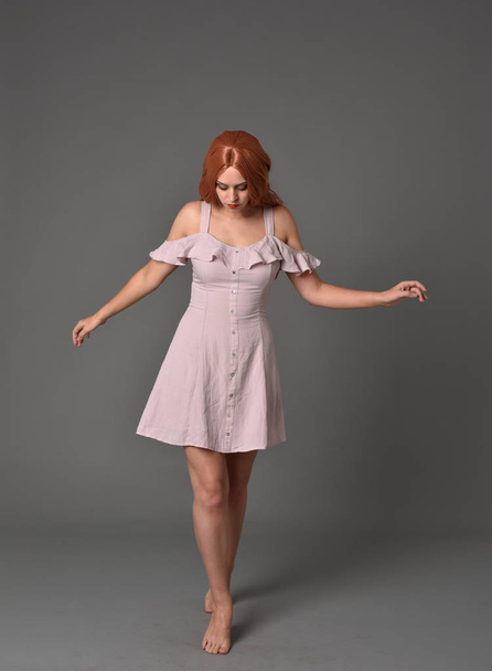 portrait pleine longueur de fille portant une robe d'été rose. pose debout sur fond de studio gris
 - Photo, image