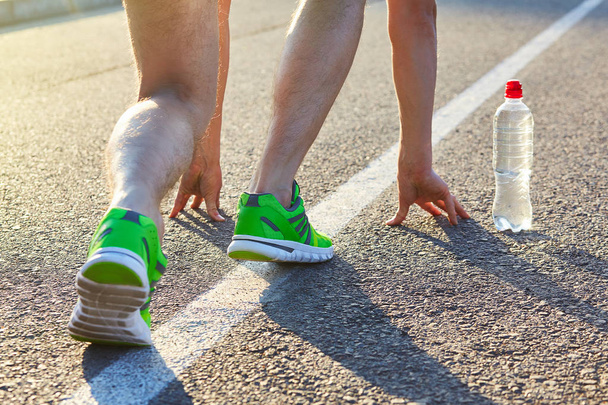 Loper man voeten waarop weg close-up op schoen. Mannelijke atleet jogger fitnesstraining in wellness-concept. Mannelijke atleten in loopschoenen. Joggen - Foto, afbeelding