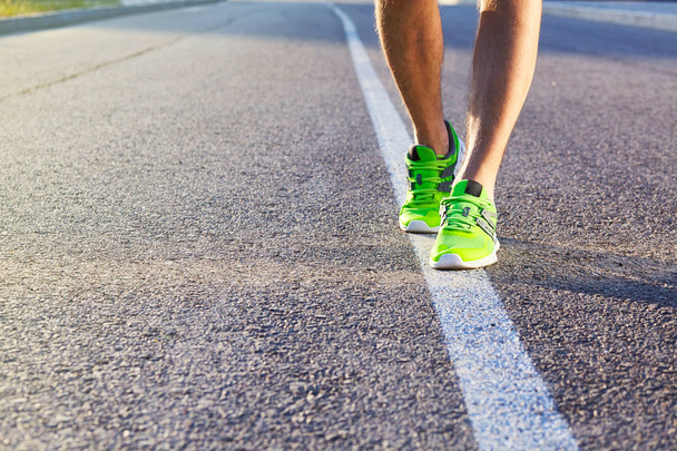 Corredor hombre pies corriendo en la carretera primer plano en zapato. Ejercicio de atleta de fitness masculino en concepto de bienestar. Atletas masculinos en zapatillas. Correr
 - Foto, Imagen