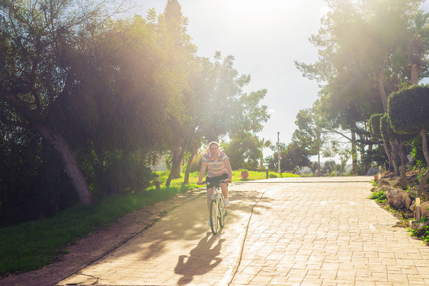 Jeune homme en forme lors d'une balade à vélo par une journée ensoleillée. - Photo, image