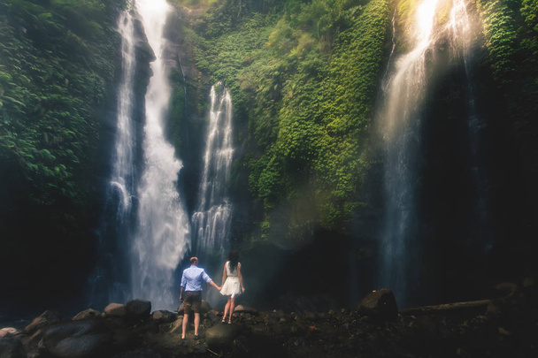 Amazing romantic view of happy couple near beautiful grand waterfall - Foto, imagen