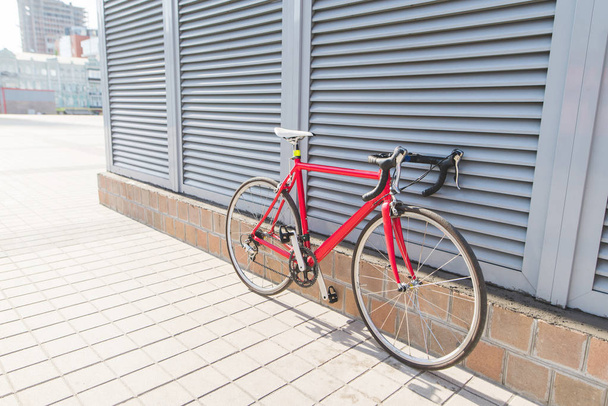 Beautiful red road bike stands near a gray wall. - Foto, Bild