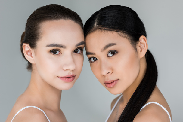 portrait of two attractive multicultural women isolated on gray background  - Фото, зображення